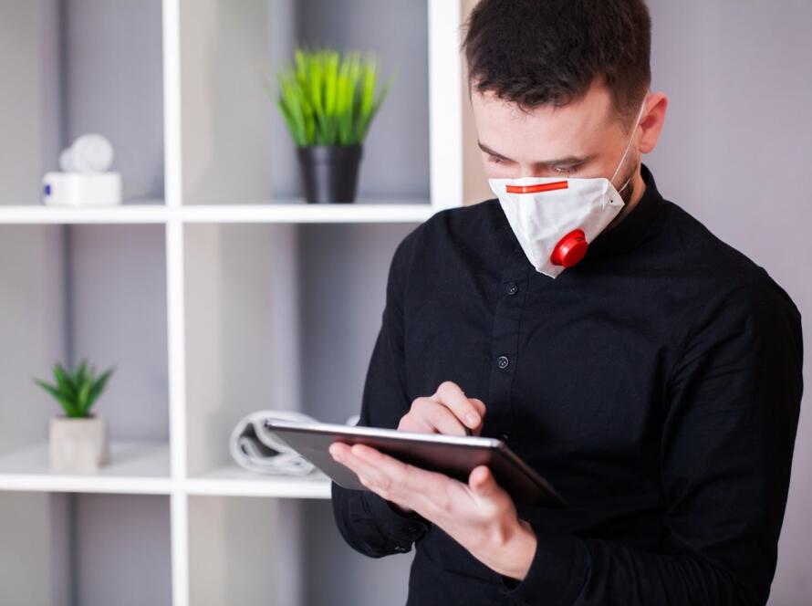 A specialist wearing a safety mask evaluates the air quality inside a residential space